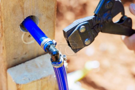 Photo for Plumber connects blue PVC pipe for water piping system - Royalty Free Image