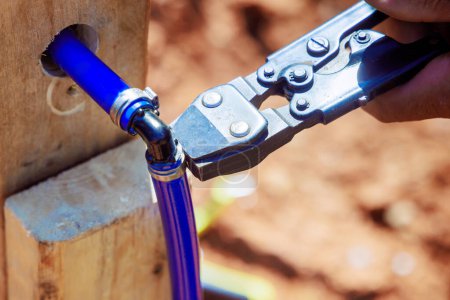 Während der Installation des Wasserleitungssystems verbindet Klempner blaues PVC-Rohr