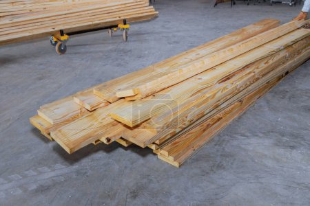 Les planches en bois empilées sur le chantier sont prêtes à être utilisées