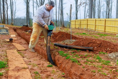 Installation de tuyaux de drainage pluvial dans les drains de tranchées pour le drainage de l'eau de pluie