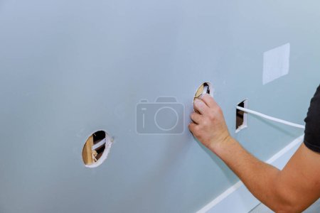 Photo for Electrician installing new current wires on an interior wall during apartment renovation - Royalty Free Image