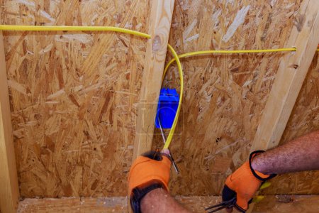 Installation elektrischer Leitungen durch einen Elektriker auf einer Wohnbaustelle