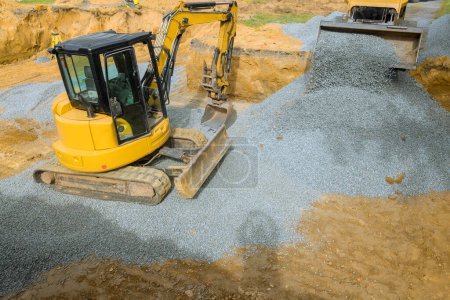 Construction sites require an excavator to fill irregularities with granite rubble base that serves as foundation for concrete
