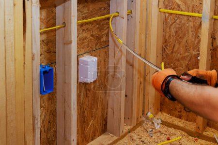 Los cables están conectados a cajas de enchufes durante la construcción de un nuevo edificio por un electricista