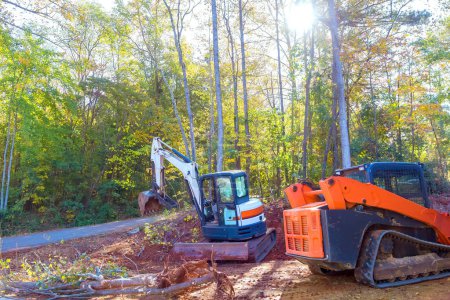 Un árbol desarraigado es desarraigado por el tractor durante la construcción, preparando el terreno para la construcción