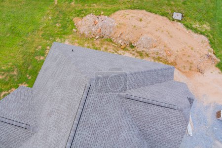In course of building new house, construction roof is being covered with rubber asphalt roof shingles