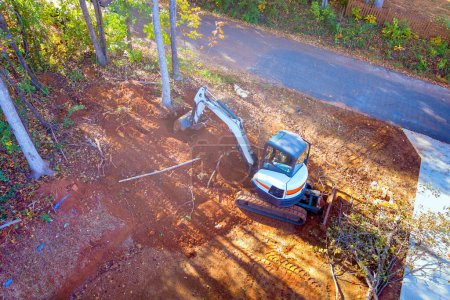 Tractor uproots trees during construction in order to clear land for building