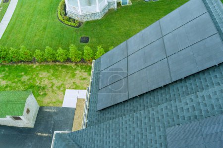 Photo for On roof of house, solar photovoltaic panels generate green power from renewable sources of energy - Royalty Free Image