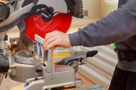 Contractor of using circular saw is cutting wooden moldings on circular saw before installing