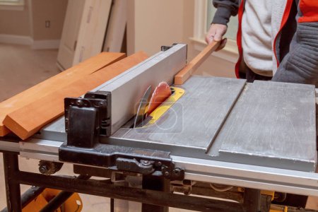 Usando una sierra de mesa eléctrica para cortar el relleno del gabinete de madera