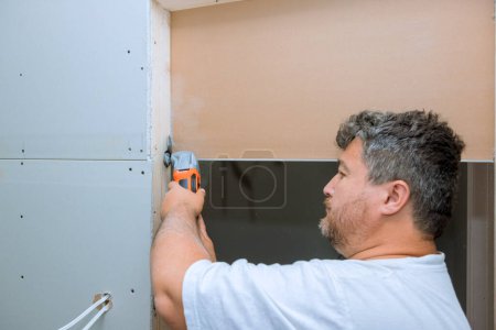 Using multi tool, worker cuts drywall