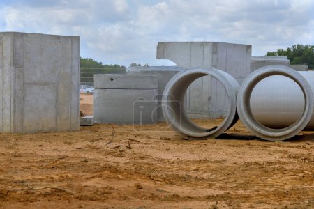 Foto de Apilamiento de pozos de drenaje de hormigón para la descarga de agua en obra antes de su instalación - Imagen libre de derechos