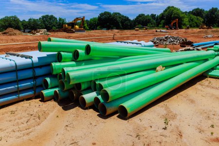 Des tuyaux en PVC vert sont utilisés sur les chantiers de construction pour la pose de conduites d'eau pour les maisons neuves