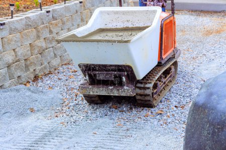 Dumper-Raupenschubkarre wird von Bauarbeitern beim Gießen von Betonzement verwendet