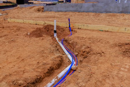 Colocación en tuberías de agua subterráneas tuberías sanitarias para verter hormigón en la fundación de la nueva casa