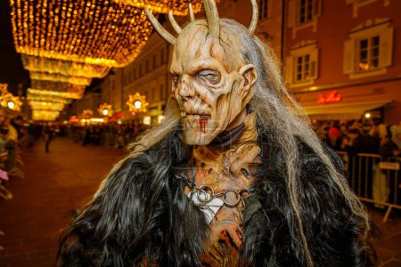 Foto de KLAGENFURT, AUSTRIA - 19 DE NOVIEMBRE DE 2022: Hombre no identificado lleva máscara de Krampus (diablo) en la tradicional procesión "Krampuslauf" en Klagenfurt, Austria - Imagen libre de derechos