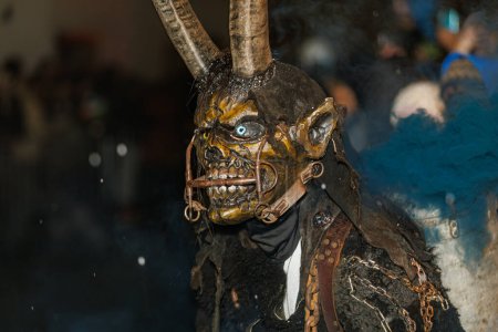 Foto de PODKOREN, ESLOVENIJA - 24 DE NOVIEMBRE DE 2023: Un hombre no identificado lleva máscara de Krampus (diablo) en la tradicional procesión "Parkelj gathering" en Podkoren, Eslovenia - Imagen libre de derechos