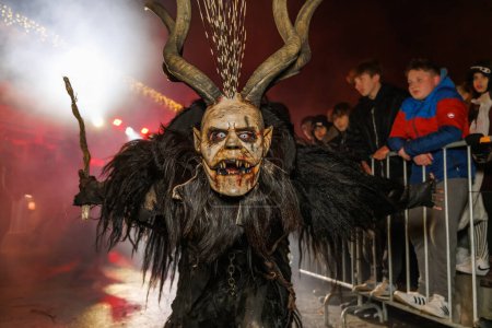 Téléchargez les photos : PODKOREN, SLOVENIJA - 24 NOVEMBRE 2023 : Un homme non identifié porte le masque Krampus (diable) lors de la procession traditionnelle "Parkelj gathering" à Podkoren, Slovénie - en image libre de droit