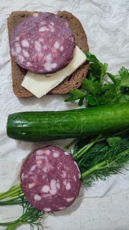 Trockene geräucherte Wurst, Sandwich mit Butter, grünes frisches Gurkengemüse, Petersilie-Essen Mittagsessen Kochen, Frühstück. Hochwertiges Foto