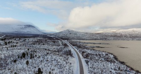 Schneebedeckte Straße, die sich in die arktische Landschaft erstreckt. Hochwertiges 4k Filmmaterial