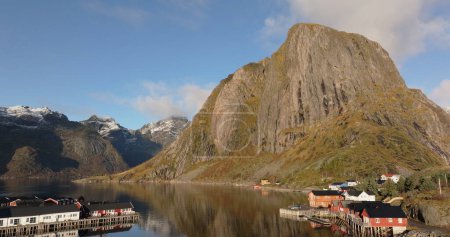 Sunny Morning Over Reine: Traditional Rorbuer and Rugged Cliffs of Lofoten. High quality 4k footage