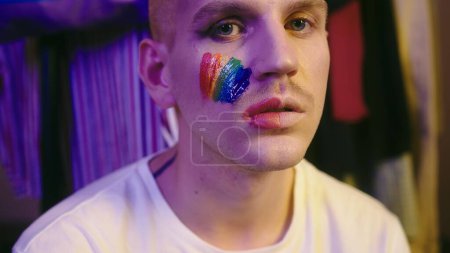 Direct Gaze: LGBT Individual with Pride Flag on Cheek. High quality 4k footage