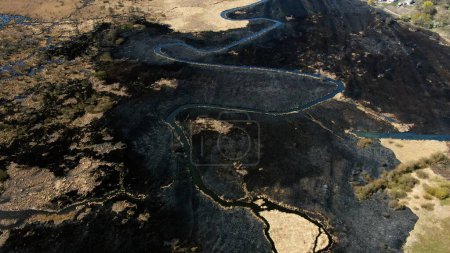 Aerial View of Serpentine Waterway Cutting Through Burnt Landscape. High quality 4k footage