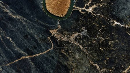 Aerial View of Isolated Water Body in Burnt Landscape. High quality 4k footage