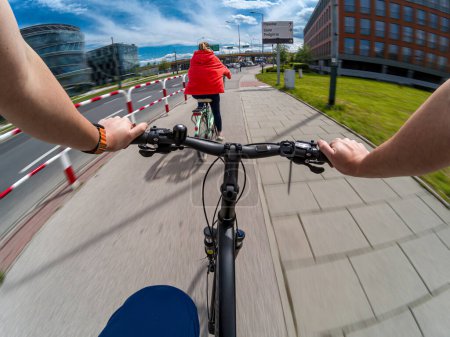 Téléchargez les photos : Un couple de vélos ensemble par temps ensoleillé dans une zone urbaine. Vue à la première personne - POV - en image libre de droit