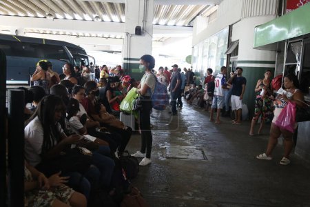 Foto de Salvador, bahia, Brasil - 19 de diciembre de 2022: pasajeros subiendo a un autobús en la estación de autobuses de Salvador. - Imagen libre de derechos