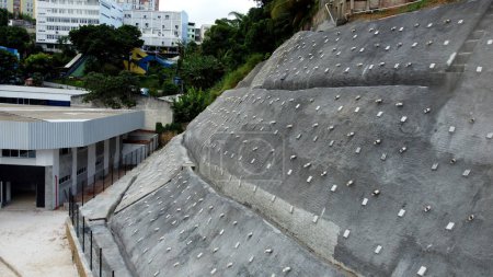 Photo for Salvador, bahia, brazil - april 15, 2023: Concrete barrier to contain a hillside next to residences in the city of Salvador. - Royalty Free Image