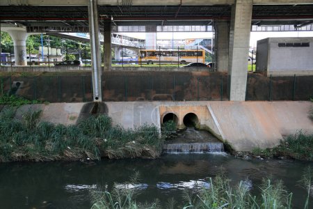Téléchargez les photos : Salvador, bahia, brésil - 17 mai 2023 : tuyau jaillissant des eaux usées dans un ruisseau de la ville de Salvador. - en image libre de droit