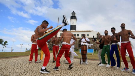 Foto de Salvador, bahia, brasil - 4 de julio de 2023: capoeiristas realizan en Farol da Barra durante el lanzamiento de la fábrica china de automóviles BYD, que abrirá una fábrica en la ciudad de Camacari. - Imagen libre de derechos