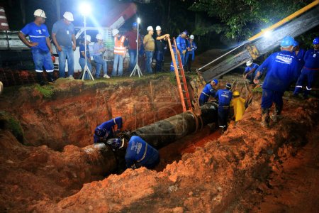 Téléchargez les photos : Salvador, bahia, brésil - 18 juin 2023 : Des employés d'ambassade réparent des conduites du réseau de distribution d'eau potable au Salvador. - en image libre de droit
