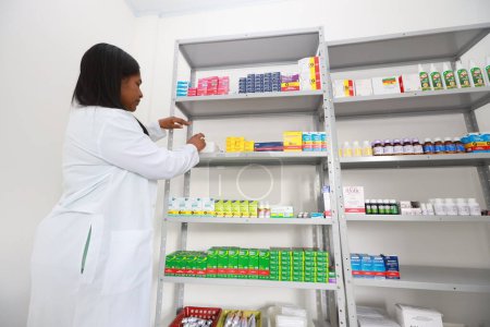 lencois, bahia, brazil - may 26, 2024: pharmacist is seen next to a shelf of medicines in a pharmacy at a medical center in the city of Lencois.