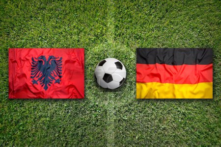 Albanien vs. Deutschland Fahnen auf grünem Fußballfeld