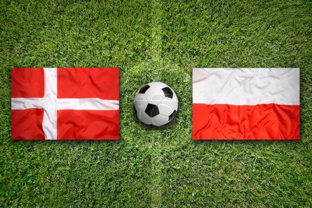 Denmark vs. Poland flags on green soccer field