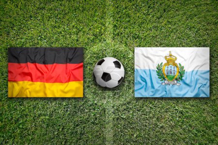 Téléchargez les photos : L'Allemagne contre Saint-Marin drapeaux sur un terrain de football vert - en image libre de droit
