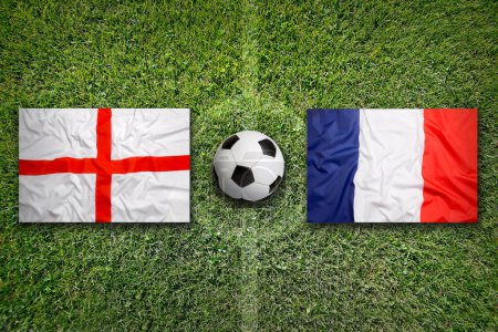 Inglaterra vs. Francia banderas en el campo de fútbol verde