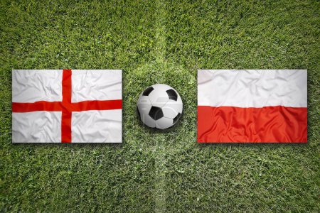 Inglaterra vs. Polonia banderas en el campo de fútbol verde