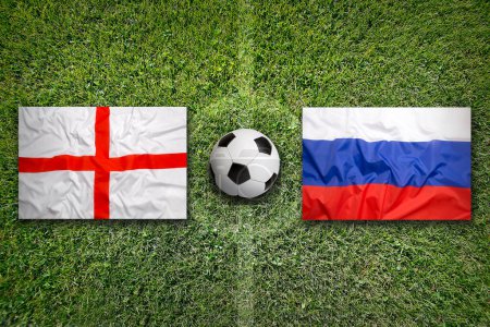 Inglaterra vs. Rusia banderas en el campo de fútbol verde
