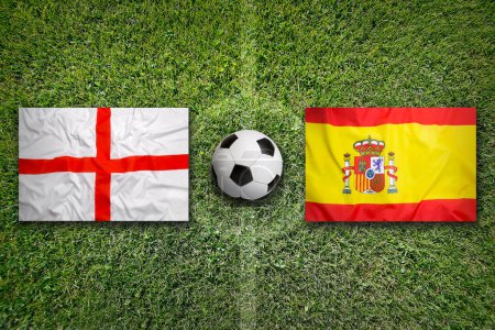 Banderas de Inglaterra vs. España en el campo de fútbol verde