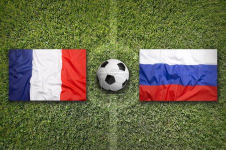 Francia vs. Rusia banderas en el campo de fútbol verde