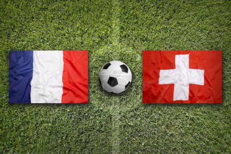 Francia vs. Suiza banderas en el campo de fútbol verde