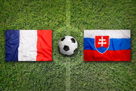 Francia vs. Eslovaquia banderas en el campo de fútbol verde