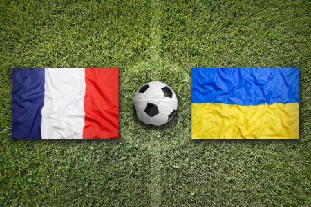 Drapeaux de la France contre l'Ukraine sur un terrain de football vert