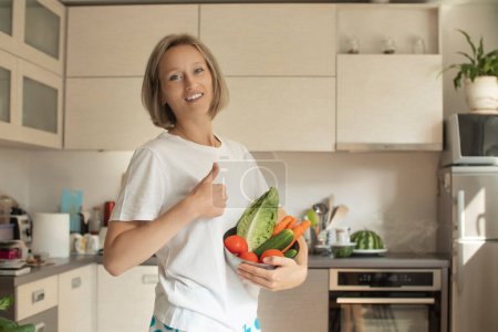 Téléchargez les photos : Beauté jeune femme souriante positive avec des légumes dans la cuisine - en image libre de droit