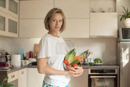 Téléchargez les photos : Beauté jeune femme souriante positive avec des légumes dans la cuisine - en image libre de droit