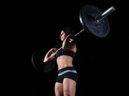 Téléchargez les photos : Forte femme levant haltère lourd dans la salle de gym - en image libre de droit