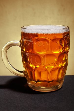 Téléchargez les photos : Mug with light beer and foam on brown background - en image libre de droit